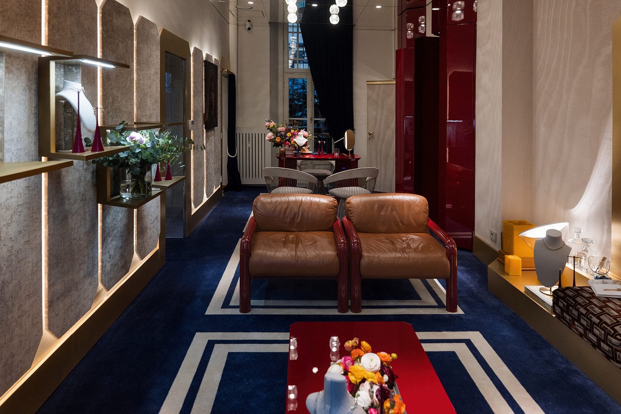 Interno della Maison Antoine in Via Montenapoleone 18, Milano: poltrone in pelle marrone e arredi rossi su tappeto blu