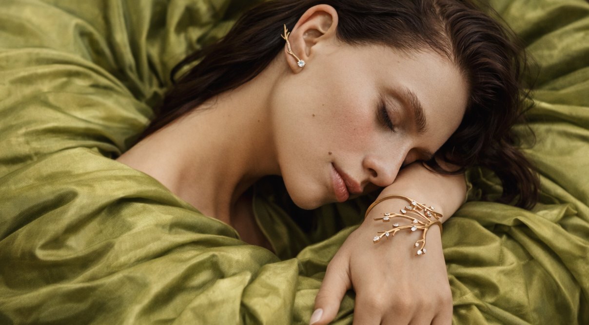 Modella avvolta in seta verde smeraldo con bracciale Antoine Rinascimento in oro rosa a ramo fiorito
