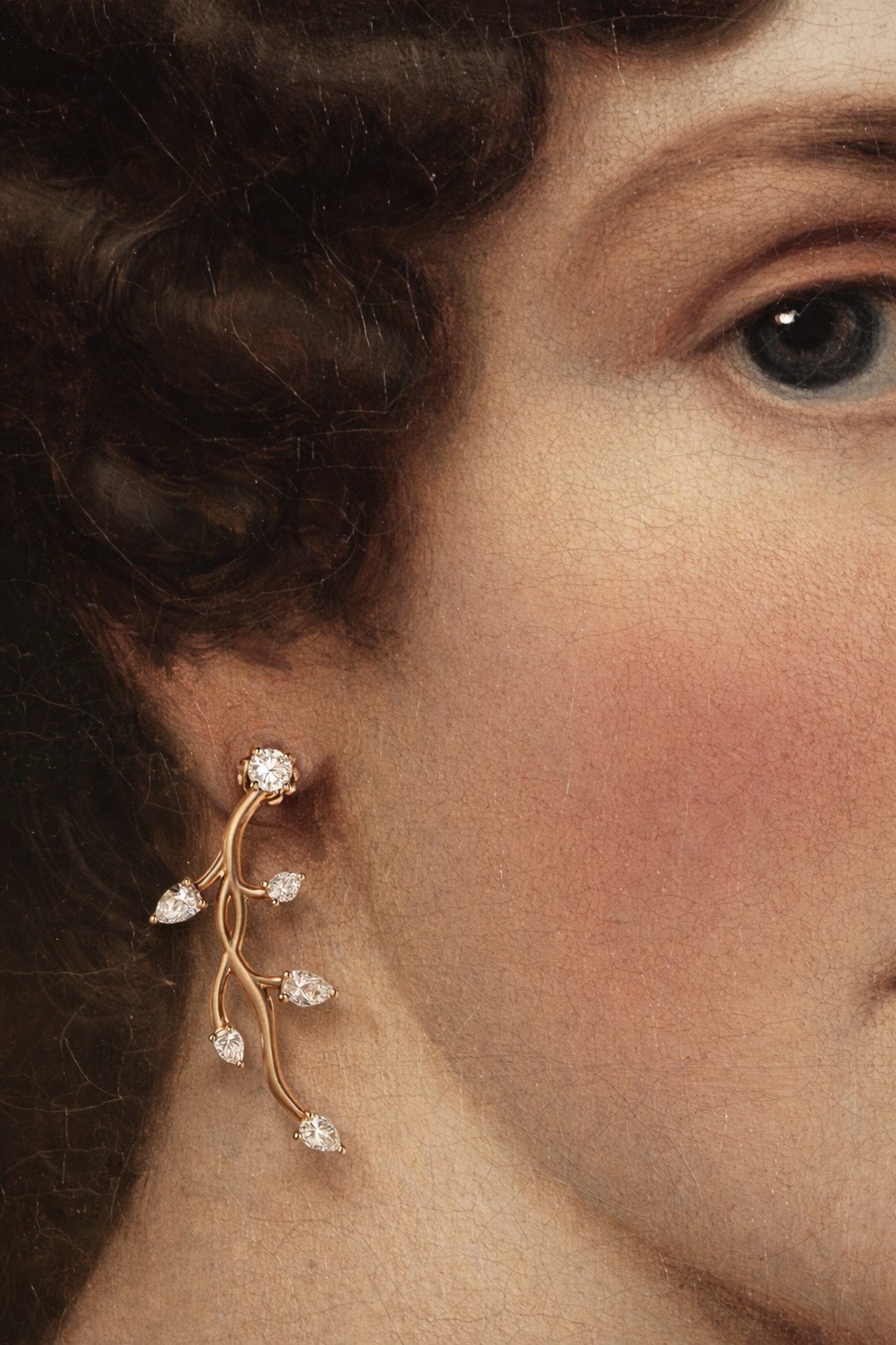 Dettaglio del viso di una modella con orecchino Antoine Rinascimento in oro rosa a ramo fiorito con diamanti